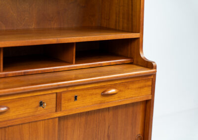 Teak secretary/bookcase by Harald Nielsen (Denmark, 1960s). A nicely designed and multifunctional piece containing four sliding doors, two drawers, a convenient pull-out leaf and some open storage space. Featuring nice handles and a warm natural wood grain. It is in splendid condition and the original key is included.