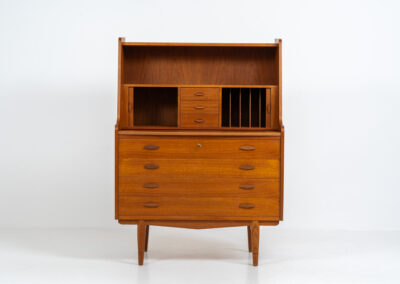 Stunning secretary with tambour doors by Storgaard Nielsen Møbelfabrik (Denmark, 1960s). It looks absolutely amazing! This teak secretary is a highly versatile piece featuring beautiful handles, a pull-out leaf, lots of storage space and beautiful hidden tambour doors. It’s in very good condition with some minor traces of age and use.