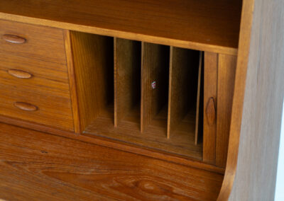 Stunning secretary with tambour doors by Storgaard Nielsen Møbelfabrik (Denmark, 1960s). It looks absolutely amazing! This teak secretary is a highly versatile piece featuring beautiful handles, a pull-out leaf, lots of storage space and beautiful hidden tambour doors. It’s in very good condition with some minor traces of age and use.