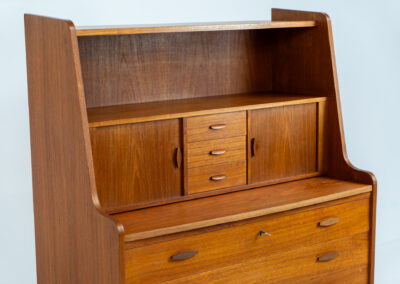 Stunning secretary with tambour doors by Storgaard Nielsen Møbelfabrik (Denmark, 1960s). It looks absolutely amazing! This teak secretary is a highly versatile piece featuring beautiful handles, a pull-out leaf, lots of storage space and beautiful hidden tambour doors. It’s in very good condition with some minor traces of age and use.