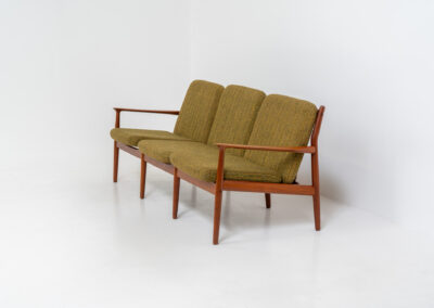 Impressive 3-seater sofa by Grete Jalk for Glostrup (Denmark, 1960s). What an eye catcher.. it features a solid teak frame which is beautifully sculpted and the original cushions! The green/yellow wool fabric is original aswell and remains in amazing condition. Obviously an example of true Scandinavian craftsmanship. It is a pleasure for the eyes and a pleasure to sit in! Marked by maker.