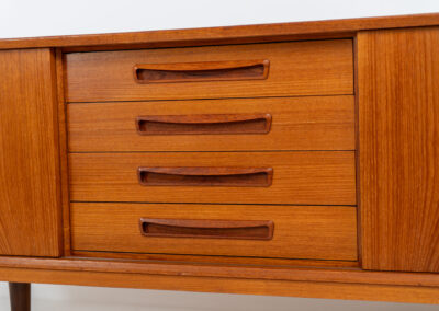 Beautiful Danish sideboard in teak, 1960s. The designer is unknown for now, but it is clearly a well-built and very aesthetic piece! It contains two sliding doors with shelves on the inside and four drawers with stunning organic inset handles on them. Another feature on this one is that it has a veneered backside, so it can be placed in the center of a room, as a room devider for example. The sideboard is in very good condition!