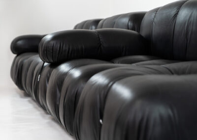“Camaleonda” sofa by Mario Bellini for C&B Italia, 1970s This particular Camaleonda sofa represents a first edition crafted by C&B Italia, the predecessor of B&B Italia. Upholstered in its original black leather fabric, it comprises four modular sections totaling ten pieces. Originating from the 1970s, it has signs of use expected with its age, yet remains free from tears or significant scratches. The leather retains a remarkable vintage condition, adorned with a beautiful patina.