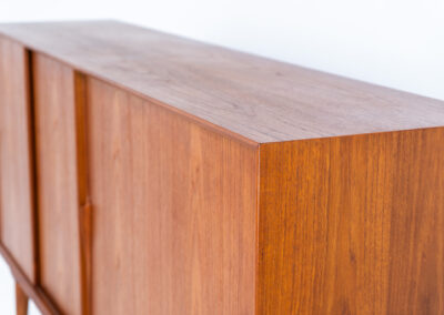 “Model 19” sideboard by Gunni Omann for Omann Jun (Denmark, 1960s). A high end teak piece containing four sliding doors, lots of storage space and eight convenient drawers on the inside. The combination of the typical Gunni Omann handles, the organic shapes and the warm golden woodgrain makes this a stunning Piece! The back is veneered aswell so it can be placed in the center of the room as a room divider for example. In very good condition, one of the handles has worn off a bit as shown on the pictures.