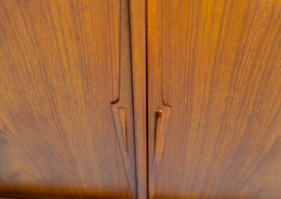 “Model 19” sideboard by Gunni Omann for Omann Jun (Denmark, 1960s). A high end teak piece containing four sliding doors, lots of storage space and eight convenient drawers on the inside. The combination of the typical Gunni Omann handles, the organic shapes and the warm golden woodgrain makes this a stunning Piece! The back is veneered aswell so it can be placed in the center of the room as a room divider for example. In very good condition, one of the handles has worn off a bit as shown on the pictures.
