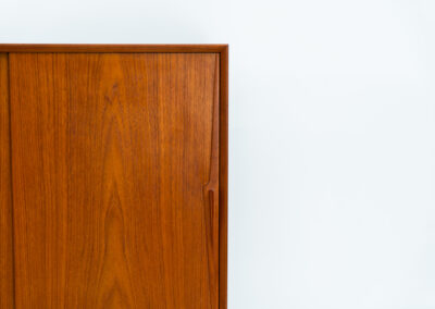 “Model 19” sideboard by Gunni Omann for Omann Jun (Denmark, 1960s). A high end teak piece containing four sliding doors, lots of storage space and eight convenient drawers on the inside. The combination of the typical Gunni Omann handles, the organic shapes and the warm golden woodgrain makes this a stunning Piece! The back is veneered aswell so it can be placed in the center of the room as a room divider for example. In very good condition, one of the handles has worn off a bit as shown on the pictures.