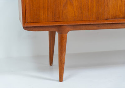 “Model 19” sideboard by Gunni Omann for Omann Jun (Denmark, 1960s). A high end teak piece containing four sliding doors, lots of storage space and eight convenient drawers on the inside. The combination of the typical Gunni Omann handles, the organic shapes and the warm golden woodgrain makes this a stunning Piece! The back is veneered aswell so it can be placed in the center of the room as a room divider for example. In very good condition, one of the handles has worn off a bit as shown on the pictures.
