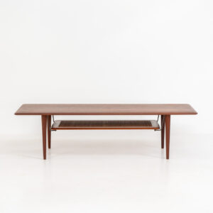 Highly collectible FD-516 coffee table by Peter Hvidt & Orla Mølgaard for France & Søn (Denmark, 1960s). This rare and important FD-516 model features a solid teak table top and solid legs. It has an additional magazine area made of rattan mesh, which is worn by brass fittings. An example of a highly detailed and high quality Scandinavian design classic in very good condition. Marked by maker.