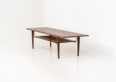 Highly collectible FD-516 coffee table by Peter Hvidt & Orla Mølgaard for France & Søn (Denmark, 1960s). This rare and important FD-516 model features a solid teak table top and solid legs. It has an additional magazine area made of rattan mesh, which is worn by brass fittings. An example of a highly detailed and high quality Scandinavian design classic in very good condition. Marked by maker.