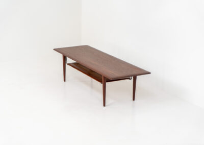 Highly collectible FD-516 coffee table by Peter Hvidt & Orla Mølgaard for France & Søn (Denmark, 1960s). This rare and important FD-516 model features a solid teak table top and solid legs. It has an additional magazine area made of rattan mesh, which is worn by brass fittings. An example of a highly detailed and high quality Scandinavian design classic in very good condition. Marked by maker.