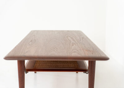 Highly collectible FD-516 coffee table by Peter Hvidt & Orla Mølgaard for France & Søn (Denmark, 1960s). This rare and important FD-516 model features a solid teak table top and solid legs. It has an additional magazine area made of rattan mesh, which is worn by brass fittings. An example of a highly detailed and high quality Scandinavian design classic in very good condition. Marked by maker.