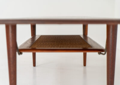 Highly collectible FD-516 coffee table by Peter Hvidt & Orla Mølgaard for France & Søn (Denmark, 1960s). This rare and important FD-516 model features a solid teak table top and solid legs. It has an additional magazine area made of rattan mesh, which is worn by brass fittings. An example of a highly detailed and high quality Scandinavian design classic in very good condition. Marked by maker.