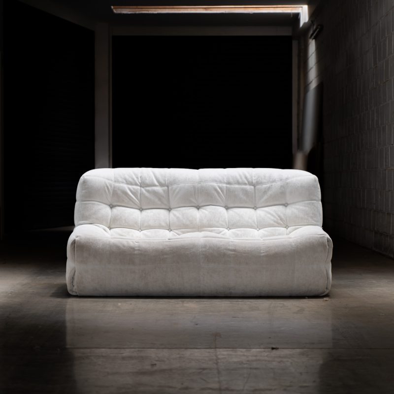 “Kashima” 2-seater sofa by Michel Ducaroy for Ligne Roset (France, 1970s). This example remains in original condition with the original off-white alcantara fabric. The fabric is in good vintage condition, the left side has a little more seat traces then the right side, but overall in very nice condition.