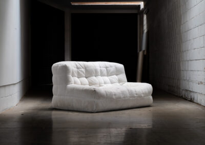 “Kashima” 2-seater sofa by Michel Ducaroy for Ligne Roset (France, 1970s). This example remains in original condition with the original off-white alcantara fabric. The fabric is in good vintage condition, the left side has a little more seat traces then the right side, but overall in very nice condition.