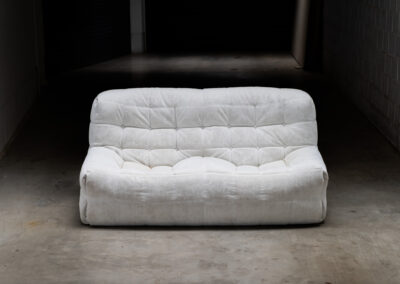 “Kashima” 2-seater sofa by Michel Ducaroy for Ligne Roset (France, 1970s). This example remains in original condition with the original off-white alcantara fabric. The fabric is in good vintage condition, the left side has a little more seat traces then the right side, but overall in very nice condition.