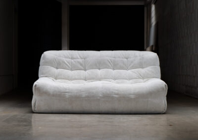 “Kashima” 2-seater sofa by Michel Ducaroy for Ligne Roset (France, 1970s). This example remains in original condition with the original off-white alcantara fabric. The fabric is in good vintage condition, the left side has a little more seat traces then the right side, but overall in very nice condition.