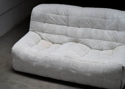“Kashima” 2-seater sofa by Michel Ducaroy for Ligne Roset (France, 1970s). This example remains in original condition with the original off-white alcantara fabric. The fabric is in good vintage condition, the left side has a little more seat traces then the right side, but overall in very nice condition.