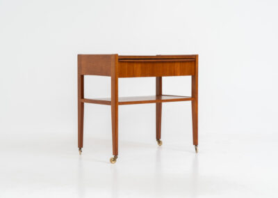 Danish trolley / sidetable in teak, 1960s A simple rolling sidetable with one drawer featuring a nicely sculpted handle, a warm woodgrain and some brass details on the wheels. In good condition with normal using traces.