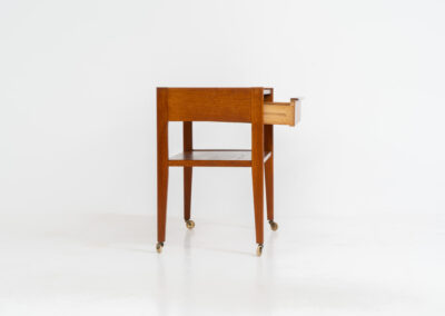 Danish trolley / sidetable in teak, 1960s A simple rolling sidetable with one drawer featuring a nicely sculpted handle, a warm woodgrain and some brass details on the wheels. In good condition with normal using traces.