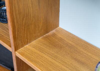 Oak bookcase by Domino Møbler (Denmark, 1960s). A simple bookcase in oak with a white back plate. It’s not very deep so it doesn’t take much space in the room. In good condition with some visible traces of wear and tear.