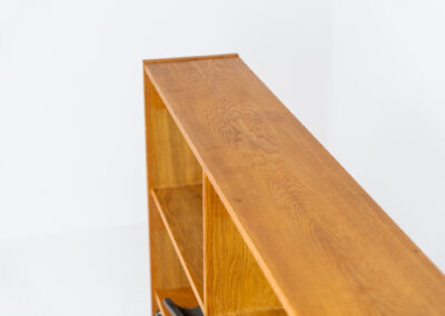 Oak bookcase by Domino Møbler (Denmark, 1960s). A simple bookcase in oak with a white back plate. It’s not very deep so it doesn’t take much space in the room. In good condition with some visible traces of wear and tear.