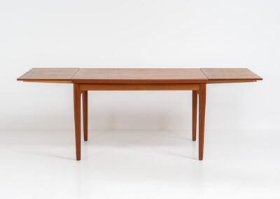 Extendable dining table by Grete Jalk for Glostrup (Denmark, 1960s). A well-know piece by one of Denmarks most prominent designers, Grete Jalk. This teak beauty features signature sculpted legs, nicely rounded solid edges and a unique boat shaped table top with a mesmerizing woodgrain. It is easily extendable with two draw leaves that are cleverly stored underneath the table top. This piece presents itself in amazing condition!