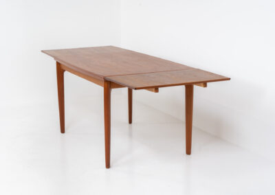 Extendable dining table by Grete Jalk for Glostrup (Denmark, 1960s). A well-know piece by one of Denmarks most prominent designers, Grete Jalk. This teak beauty features signature sculpted legs, nicely rounded solid edges and a unique boat shaped table top with a mesmerizing woodgrain. It is easily extendable with two draw leaves that are cleverly stored underneath the table top. This piece presents itself in amazing condition!