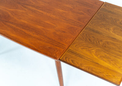 Extendable dining table by Grete Jalk for Glostrup (Denmark, 1960s). A well-know piece by one of Denmarks most prominent designers, Grete Jalk. This teak beauty features signature sculpted legs, nicely rounded solid edges and a unique boat shaped table top with a mesmerizing woodgrain. It is easily extendable with two draw leaves that are cleverly stored underneath the table top. This piece presents itself in amazing condition!