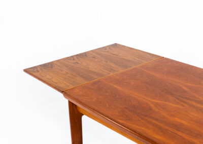 Extendable dining table by Grete Jalk for Glostrup (Denmark, 1960s). A well-know piece by one of Denmarks most prominent designers, Grete Jalk. This teak beauty features signature sculpted legs, nicely rounded solid edges and a unique boat shaped table top with a mesmerizing woodgrain. It is easily extendable with two draw leaves that are cleverly stored underneath the table top. This piece presents itself in amazing condition!