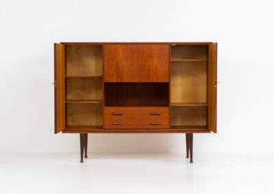 Teak highboard by van Pelt Belgium (Belgium, 1960s). A minimalistic piece made with high quality. It contains two doors with adjustable shelves on this inside, a drop-door with storage space for glasses and bottles, two drawers and an open shelve. The lock of the right door doesn’t work anymore, the key is fixed and the door closes with a magnet. The other locks still work smoothly. The wood is in very good condition with a few spots on the top and on the right side.