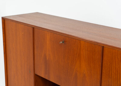 Teak highboard by van Pelt Belgium (Belgium, 1960s). A minimalistic piece made with high quality. It contains two doors with adjustable shelves on this inside, a drop-door with storage space for glasses and bottles, two drawers and an open shelve. The lock of the right door doesn’t work anymore, the key is fixed and the door closes with a magnet. The other locks still work smoothly. The wood is in very good condition with a few spots on the top and on the right side.