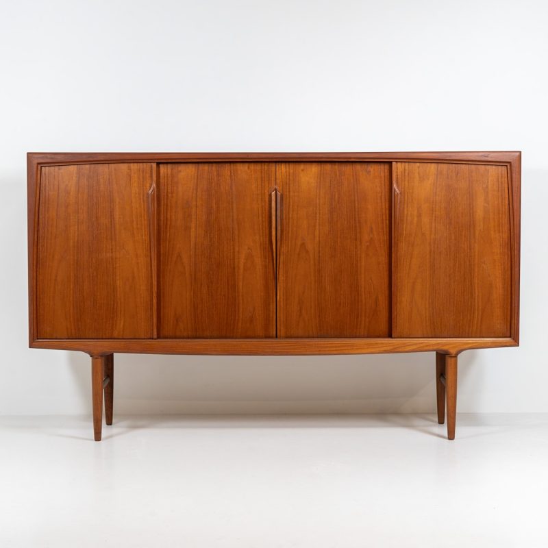 Teak highboard by Gunni Omann for Axel Christensen, ACO Møbler (Denmark, 1960s). A stunning piece containing four sliding doors, lots of storage space and five drawers on the inside. It features the typical sculpted Gunni Omann handles and nice organize shapes. This piece remains in splendid condition!