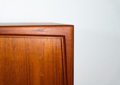 Teak highboard by Gunni Omann for Axel Christensen, ACO Møbler (Denmark, 1960s). A stunning piece containing four sliding doors, lots of storage space and five drawers on the inside. It features the typical sculpted Gunni Omann handles and nice organize shapes. This piece remains in splendid condition!