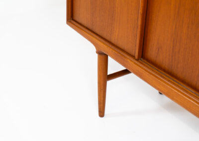 Teak highboard by Gunni Omann for Axel Christensen, ACO Møbler (Denmark, 1960s). A stunning piece containing four sliding doors, lots of storage space and five drawers on the inside. It features the typical sculpted Gunni Omann handles and nice organize shapes. This piece remains in splendid condition!