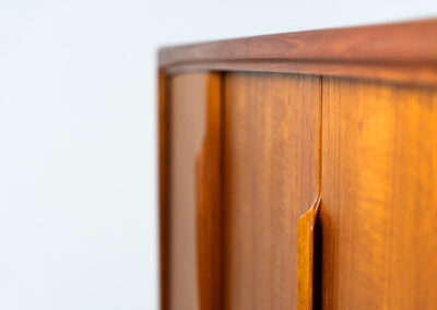 Teak highboard by Gunni Omann for Axel Christensen, ACO Møbler (Denmark, 1960s). A stunning piece containing four sliding doors, lots of storage space and five drawers on the inside. It features the typical sculpted Gunni Omann handles and nice organize shapes. This piece remains in splendid condition!