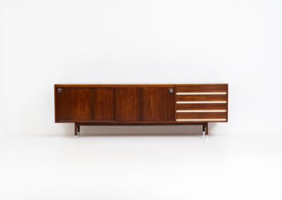 Belgian modernist sideboard in rosewood, 1960s. It features a minimalistic design with sleek lines and chrome details. It offers lots of storage space with two big sliding doors and four drawers. There are clearly traces of use and age like scratches and some color differences, but overall in good condition. We have a matching bar cabinet in stock aswell.