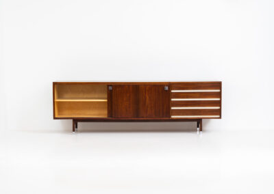 Belgian modernist sideboard in rosewood, 1960s. It features a minimalistic design with sleek lines and chrome details. It offers lots of storage space with two big sliding doors and four drawers. There are clearly traces of use and age like scratches and some color differences, but overall in good condition. We have a matching bar cabinet in stock aswell.