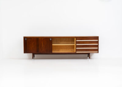 Belgian modernist sideboard in rosewood, 1960s. It features a minimalistic design with sleek lines and chrome details. It offers lots of storage space with two big sliding doors and four drawers. There are clearly traces of use and age like scratches and some color differences, but overall in good condition. We have a matching bar cabinet in stock aswell.