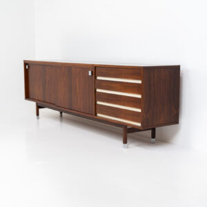 Belgian modernist sideboard in rosewood, 1960s. It features a minimalistic design with sleek lines and chrome details. It offers lots of storage space with two big sliding doors and four drawers. There are clearly traces of use and age like scratches and some color differences, but overall in good condition. We have a matching bar cabinet in stock aswell.