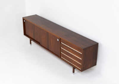 Belgian modernist sideboard in rosewood, 1960s. It features a minimalistic design with sleek lines and chrome details. It offers lots of storage space with two big sliding doors and four drawers. There are clearly traces of use and age like scratches and some color differences, but overall in good condition. We have a matching bar cabinet in stock aswell.