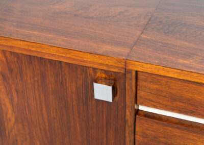 Belgian modernist sideboard in rosewood, 1960s. It features a minimalistic design with sleek lines and chrome details. It offers lots of storage space with two big sliding doors and four drawers. There are clearly traces of use and age like scratches and some color differences, but overall in good condition. We have a matching bar cabinet in stock aswell.