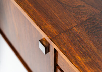 Belgian modernist sideboard in rosewood, 1960s. It features a minimalistic design with sleek lines and chrome details. It offers lots of storage space with two big sliding doors and four drawers. There are clearly traces of use and age like scratches and some color differences, but overall in good condition. We have a matching bar cabinet in stock aswell.