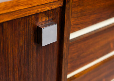 Belgian modernist sideboard in rosewood, 1960s. It features a minimalistic design with sleek lines and chrome details. It offers lots of storage space with two big sliding doors and four drawers. There are clearly traces of use and age like scratches and some color differences, but overall in good condition. We have a matching bar cabinet in stock aswell.