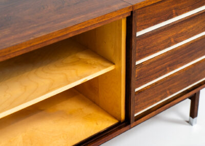 Belgian modernist sideboard in rosewood, 1960s. It features a minimalistic design with sleek lines and chrome details. It offers lots of storage space with two big sliding doors and four drawers. There are clearly traces of use and age like scratches and some color differences, but overall in good condition. We have a matching bar cabinet in stock aswell.