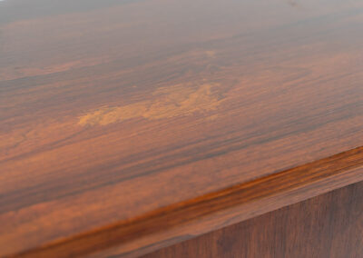 Belgian modernist bar cabinet in rosewood, 1960s. It features a minimalistic design with sleek lines and chrome details. It contains two big and two small sliding doors with lots of storage space on the inside. There are clearly traces of use and age like scratches and some color differences, but overall in good condition. We have a matching sideboard in stock aswell.