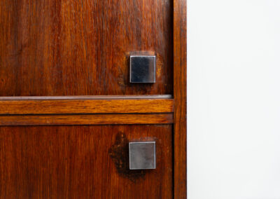 Belgian modernist bar cabinet in rosewood, 1960s. It features a minimalistic design with sleek lines and chrome details. It contains two big and two small sliding doors with lots of storage space on the inside. There are clearly traces of use and age like scratches and some color differences, but overall in good condition. We have a matching sideboard in stock aswell.