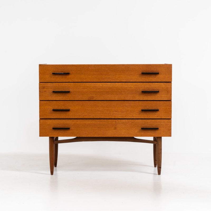 Teak chest of drawers by V-form (Belgium, 1960s). This elegant chest of drawers featured four drawers with black metal handles on them and stands on a nicely organic shaped frame. It has a beautiful natural woodgrain and has convenient dimensions. In good condition with some normal wear and tear.