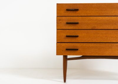 Teak chest of drawers by V-form (Belgium, 1960s). This elegant chest of drawers featured four drawers with black metal handles on them and stands on a nicely organic shaped frame. It has a beautiful natural woodgrain and has convenient dimensions. In good condition with some normal wear and tear.
