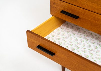 Teak chest of drawers by V-form (Belgium, 1960s). This elegant chest of drawers featured four drawers with black metal handles on them and stands on a nicely organic shaped frame. It has a beautiful natural woodgrain and has convenient dimensions. In good condition with some normal wear and tear.