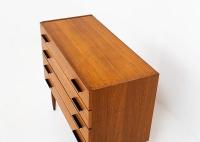 Teak chest of drawers by V-form (Belgium, 1960s). This elegant chest of drawers featured four drawers with black metal handles on them and stands on a nicely organic shaped frame. It has a beautiful natural woodgrain and has convenient dimensions. In good condition with some normal wear and tear.